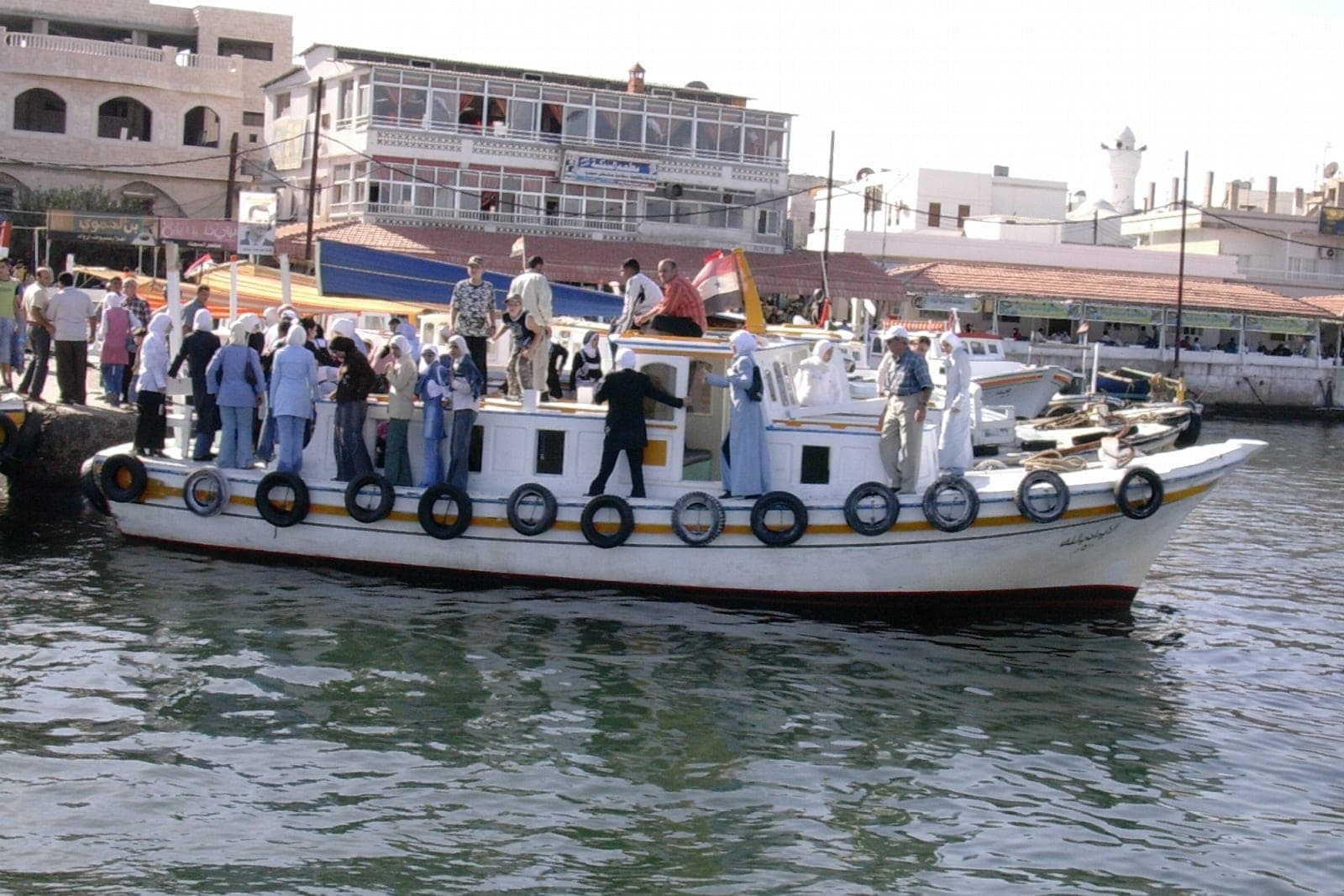 A crowded passenger boat arriving at Arwad island off Tartus